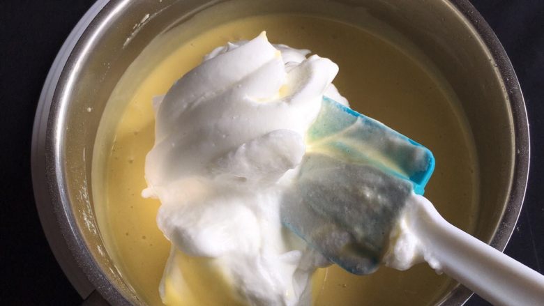 10寸蔓越梅戚风蛋糕,取三分之一的蛋白进蛋黄糊中。