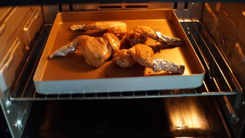 纸包鸡翅,然后放入预热好的烤箱中层，以230摄氏度，上下火烤25分钟
