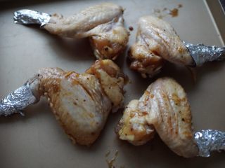 纸包鸡翅,腌制好的鸡翅放入烤盘中，鸡尖用锡纸包住