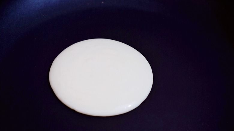 酸奶鸡蛋饼,平底锅烧热，舀一勺面糊从中间慢慢滴落，让它自然形成圆形