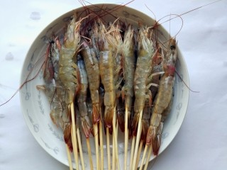 黑椒烤大虾,用竹签把虾一个个串起来。