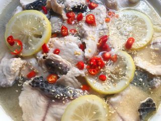 一品柠檬鱼,鱼片煮熟倒入装鱼头的碗里，撒上白芝麻和剩下的小米辣