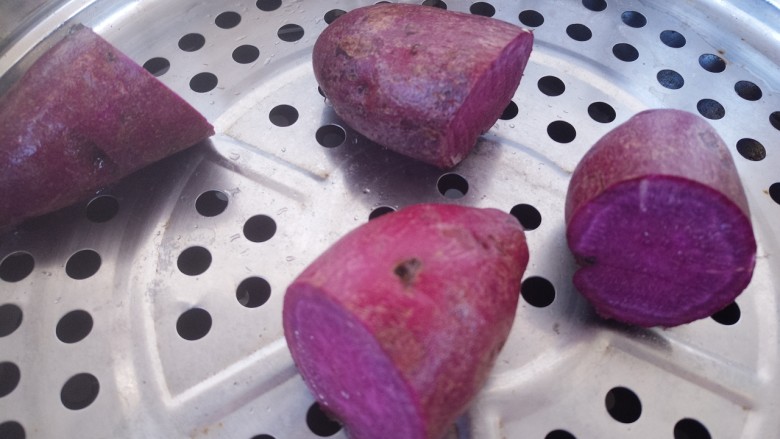 紫薯草莓团,然后把紫薯切成两半。上蒸锅蒸。