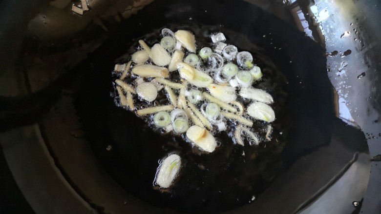 手撕包菜——这个菜狠费饭,锅中适量油烧至7成热，下入葱花，蒜片，姜丝饱出香味。