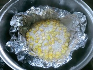 板栗鸡肉蒸饭,用锡纸做成大碗形，放入大米，加入玉米粒。放入蒸锅大火蒸。