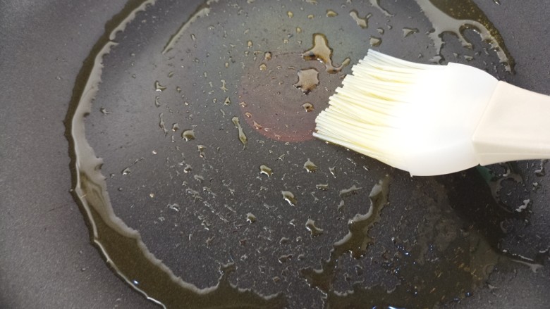 火腿肠鸡蛋饼,然后用刷子把锅里刷上油。