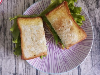 营养早餐煎蛋培根三明治,切成两半。