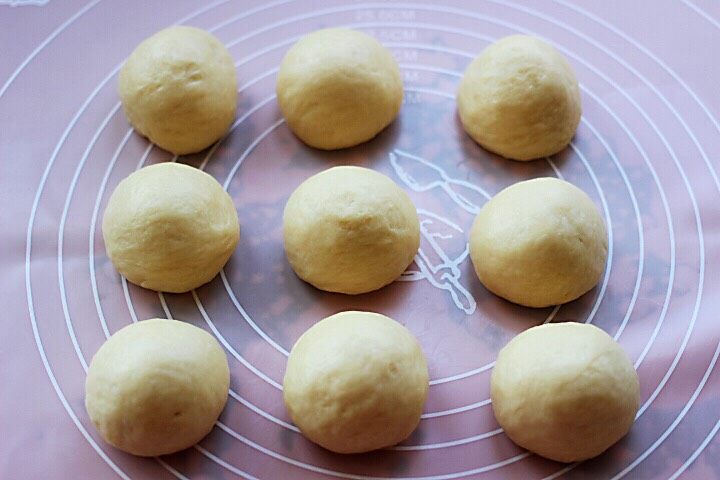 椰蓉花环面包,把面团排气揉匀后，把面团平均分成9份。