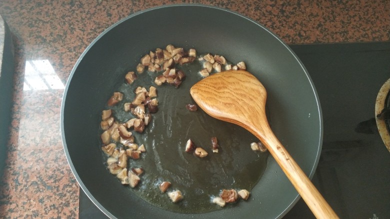 板栗香菇鸡肉焖饭,油热后，倒入香菇粒，中小火翻炒，爆香下