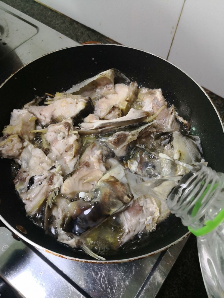 鱼头豆腐清汤,鱼头煎至两面干水金黄，倒入适当纯净水