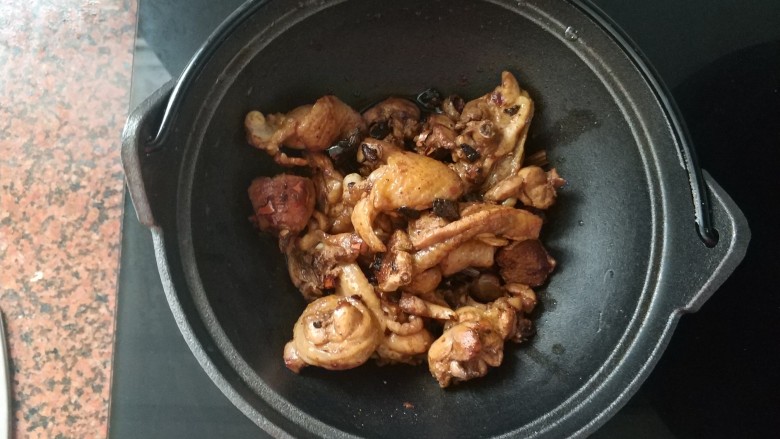芋艿烧鸡,将炒好的鸡腿肉倒入锅中，我换了铁铸锅，等下焖的时候比较均匀，家里有砂锅换成砂锅即可