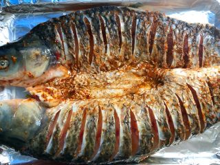 香辣烤鱼,烤盘用锡纸包好，把腌制好的鱼放入烤盘