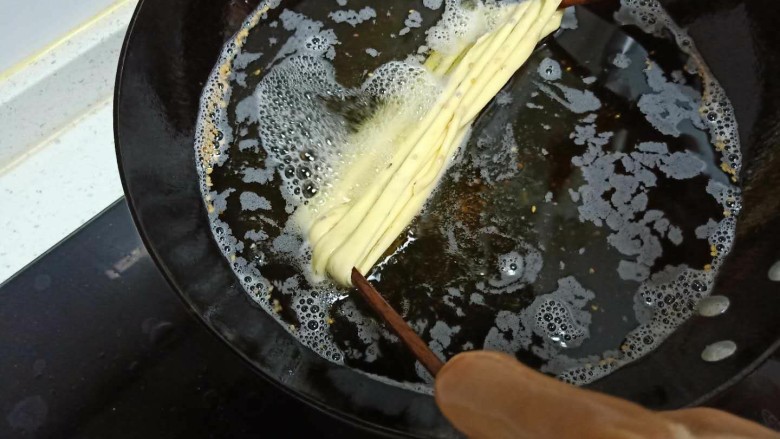 撒子,油温5层热，放入油锅后，再拉长一点，慢慢抖抖再拉长一下，直到撒子定型。