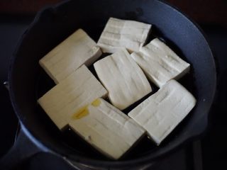 铁板豆腐,锅里热锅后放入豆腐入铁铸锅里中火煎香