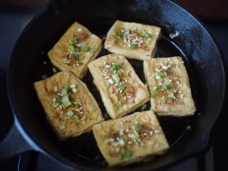 铁板豆腐,最后撒入葱花和熟的白芝麻，淋点美极鲜味汁即可