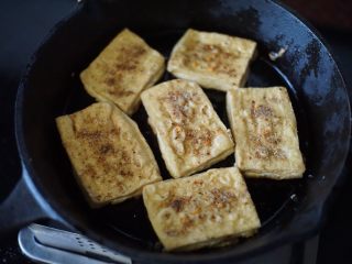 铁板豆腐,然后撒入调配好的调味料，均匀撒在每块豆腐上