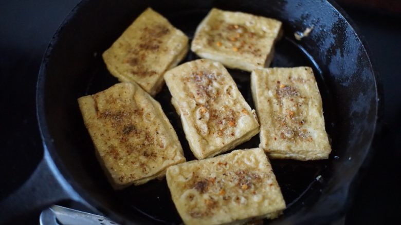 铁板豆腐,然后撒入调配好的调味料，均匀撒在每块豆腐上