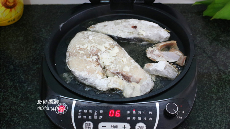 香煎马鲛鱼,将扑上淀粉的马鲛鱼放入煎烤盘内，按鱼虾自动菜单功能