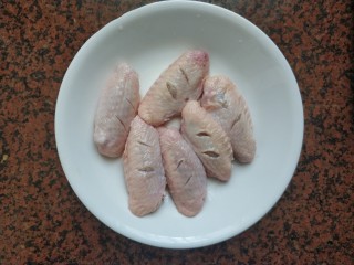 黄梅酱橙汁鸡翅,首先将鸡翅洗净后，用小刀在两面割一下，下一点点盐，腌制10分钟，去腥