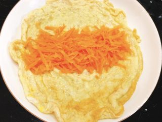 早餐鸡蛋卷,将胡萝卜铺到蛋皮中间。