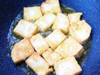 家常豆腐,豆腐切片锅里煎至两面金黄。