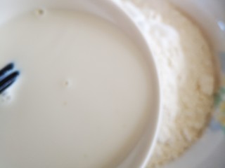 奶香大馒头,将加有酵母的牛奶溶液倒入面粉碗中
