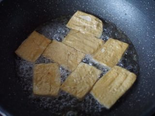 茄汁豆腐,倒出所有的油，放入煎好的豆腐，加入覆盖豆腐的开水，加入白醋煮至沸腾