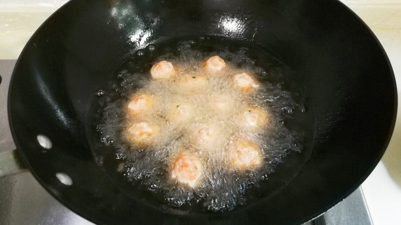 胡萝卜末肉圆,锅中放入适量食用油烧热，用勺子挖肉糊放入锅中中火炸至表面定型成浅黄色