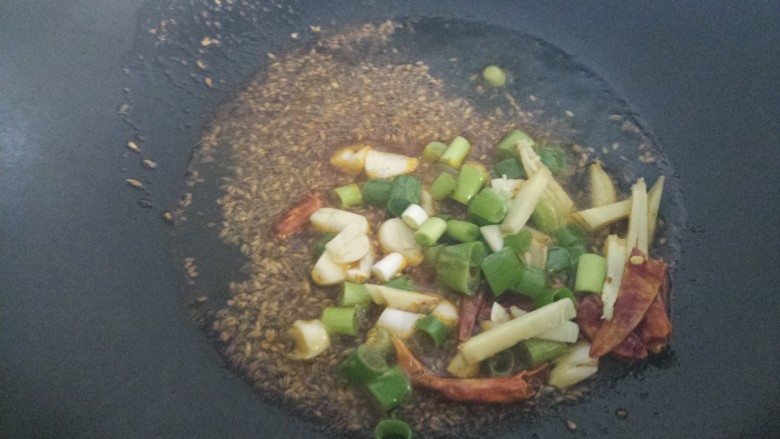 炒羊肉卷,炒出香味，然后放入葱姜蒜和干辣椒。
