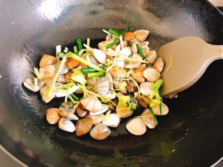 咖喱炒花蛤-好吃到舔壳,倒入贝壳、小芹菜、葱叶，炒到香味飘出，大约1分钟。