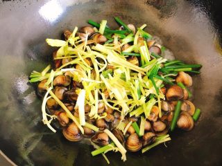 清炒蚬子,倒入小芹菜和葱叶炒香，约30秒。