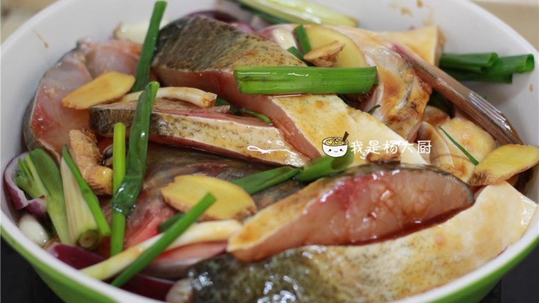 生焗鱼头,把腌好的鱼块平铺在配菜上，腌出的酱汁也要倒进去。