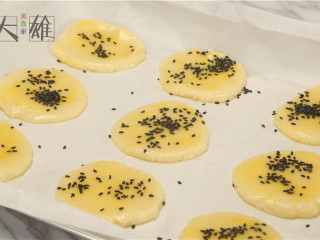 酥到不行的桃酥～～,在面饼上刷一层蛋黄液，撒一些黑芝麻