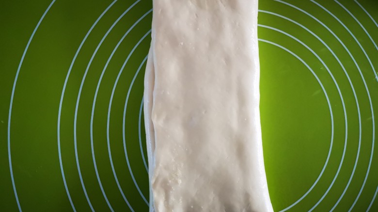 椰蓉面包条,先把左边无椰蓉处折叠过来，再把右边部分折叠过去，如上图所示