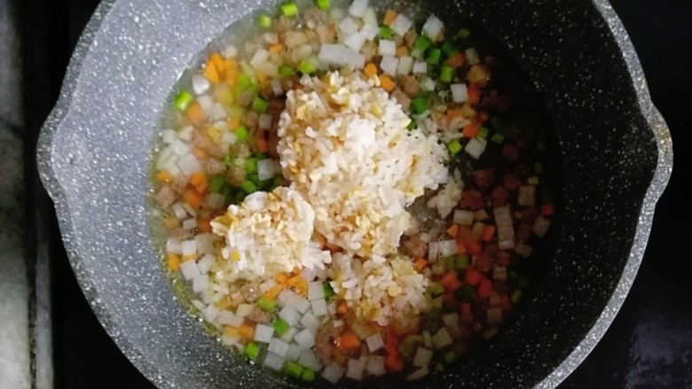 宝宝辅食—和牛蔬菜烩饭,水煮开后，倒入一碗熟米饭，翻拌均匀，小火焖煮