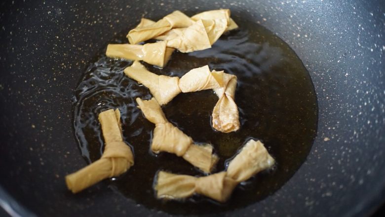 百变水果 柠檬酸菜鱼,锅里热油后放入腐皮结炸香
