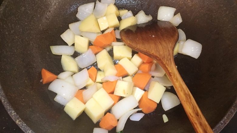 咖喱土豆鸡肉盖饭,接着倒入胡萝卜块和土豆块，翻炒片刻