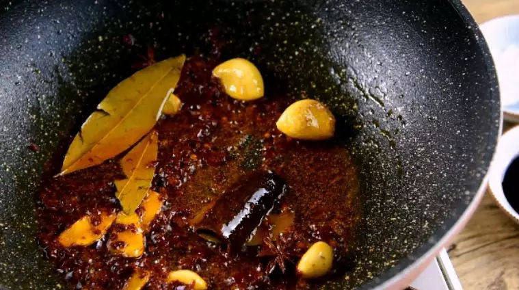 红烧牛腩的做法，细火慢炖出好味——红烧牛腩,炒香后倒入八角、桂皮、香叶、豆瓣酱炒匀