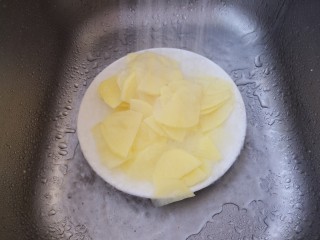 孜然土豆片,然后用水冲一下。把土豆中的淀粉去掉。