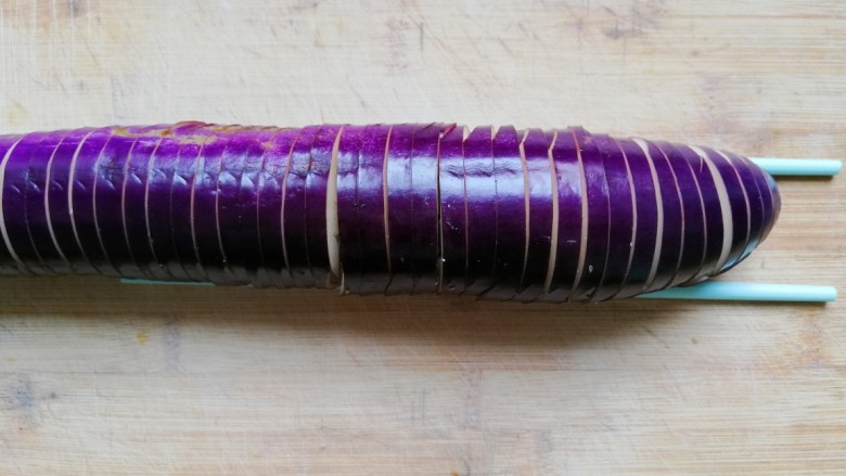 鱼香茄龙煲,将斜切好的茄子垂直翻过来，竖刀切一成5mm的片，底部不切断