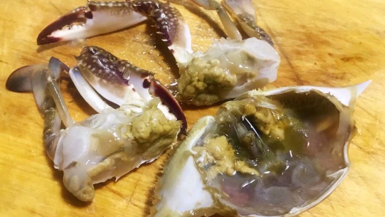 香辣吮指飞蟹,蟹子一分为二再从中间切开剥去蟹腮和清理好蟹的胃部