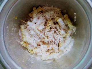 牙签玉米,把玉米串放入盆里，放上3勺淀粉、少许盐、辣椒粉、孜然粉