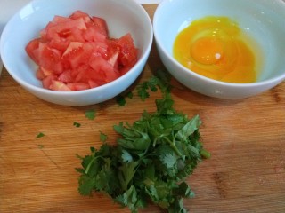 番茄鸡蛋疙瘩汤,番茄去皮切小块，鸡蛋两个打入碗中，香菜洗干净切段。