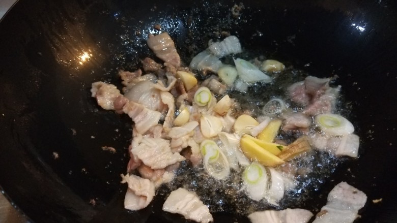 五花肉炒茭白,炒均匀出油放入葱姜蒜。