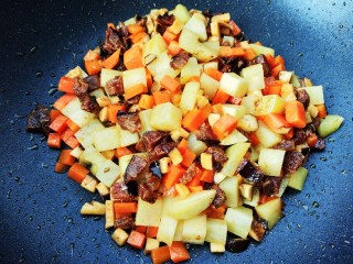 香菇腊肠土豆焖饭,倒入土豆、胡萝卜、香菇，炒至半生熟，不用完全熟了，加入适量的调料（盐、鸡粉、十三香等）（这里盐的用量要比平时炒菜时多一些做下焖饭时才更入味）