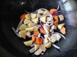 大白咖喱鸡饭,大火翻炒至鸡丁变白后下入土豆胡萝卜和洋葱继续翻炒一下。