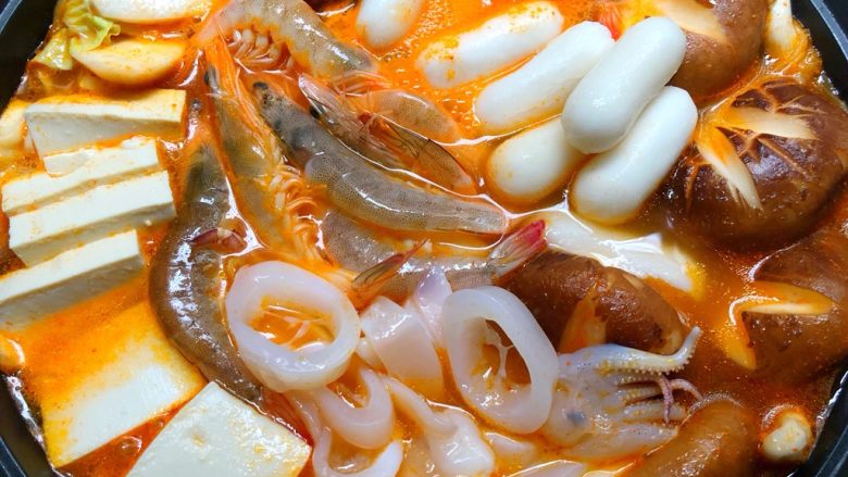 韩式泡菜锅,再放入明虾、鱿鱼、豆腐、芝士年糕煮熟