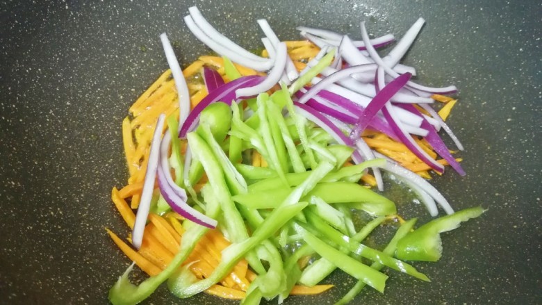 穿肠意面,下入洋葱和青椒丝翻炒均匀。