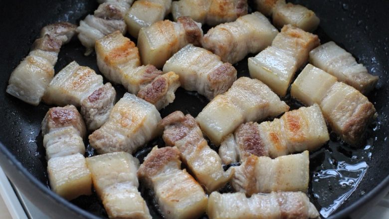 东坡肉,锅中无需放油，把五花肉放入锅中来回翻动，用小火煎至肉的表面呈焦黄状