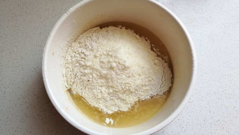 苦荞杏仁桃酥,所有粉类混合均匀，加入到玉米油混合物中，先用搅拌刀把它翻拌均匀，然后揉成面团。